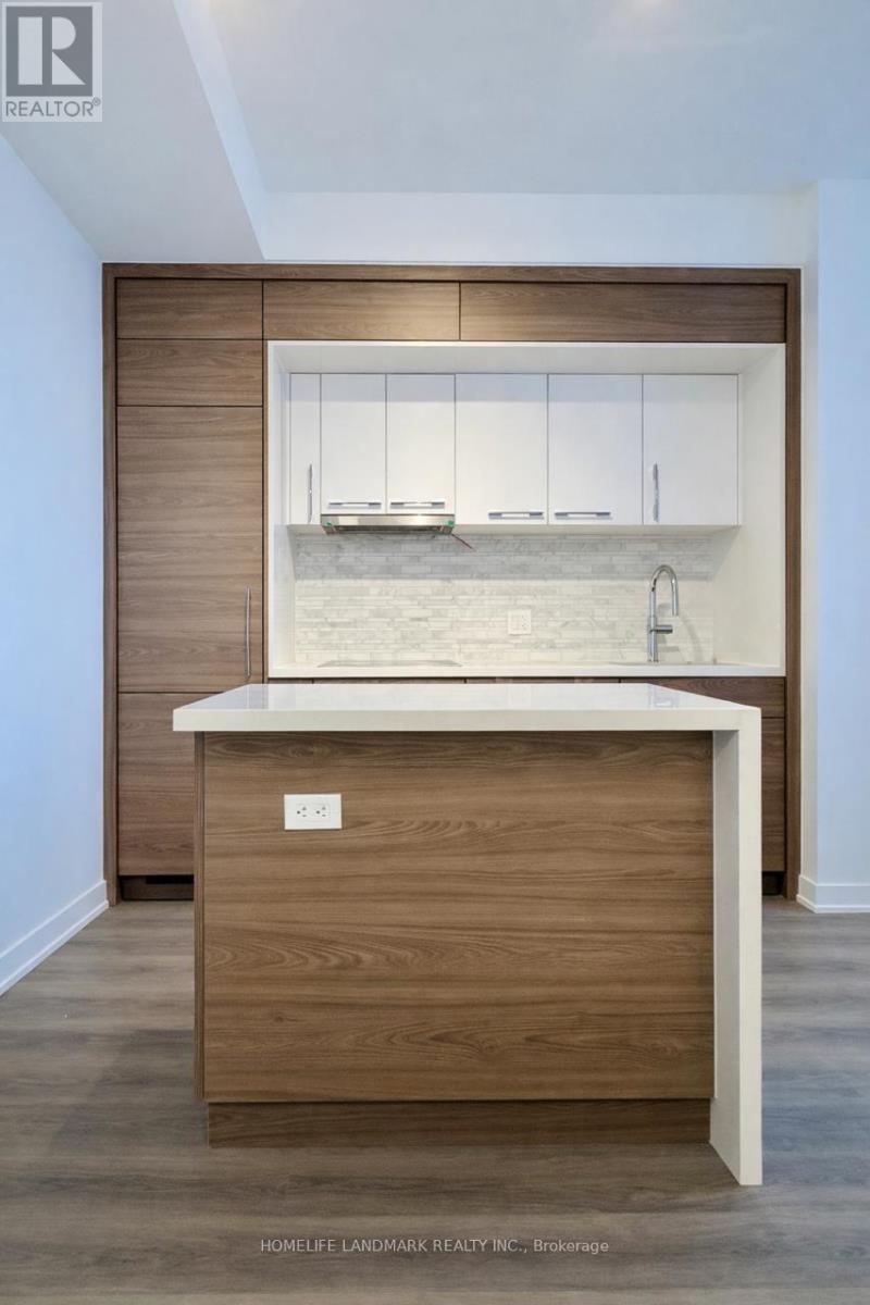 A modern kitchen with a wooden island and white countertop.