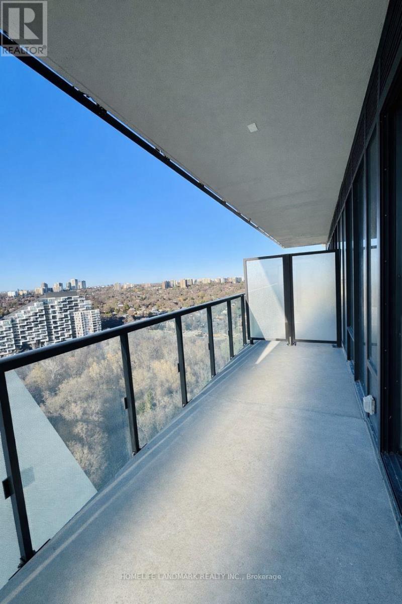 A balcony with a glass railing overlooking a cityscape.