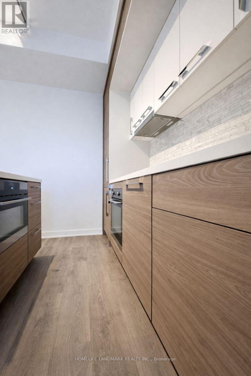 A modern kitchen with wooden cabinets and a white wall.