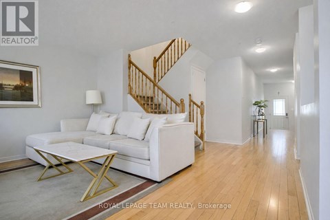 A living room with a white couch and a wooden staircase.