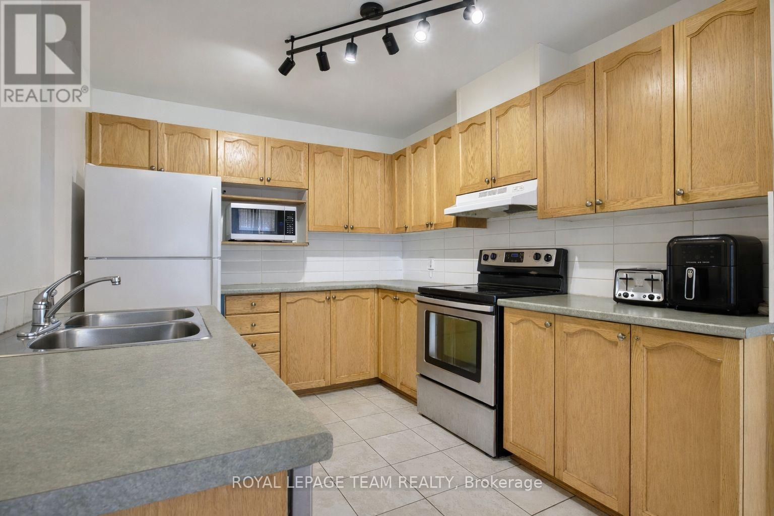 A kitchen with wooden cabinets and a stainless steel sink.