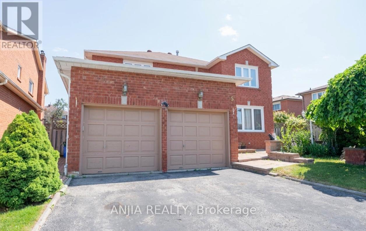 A house with a brick facade and a large garage door is for sale through Anjia Realty in Brokerage.