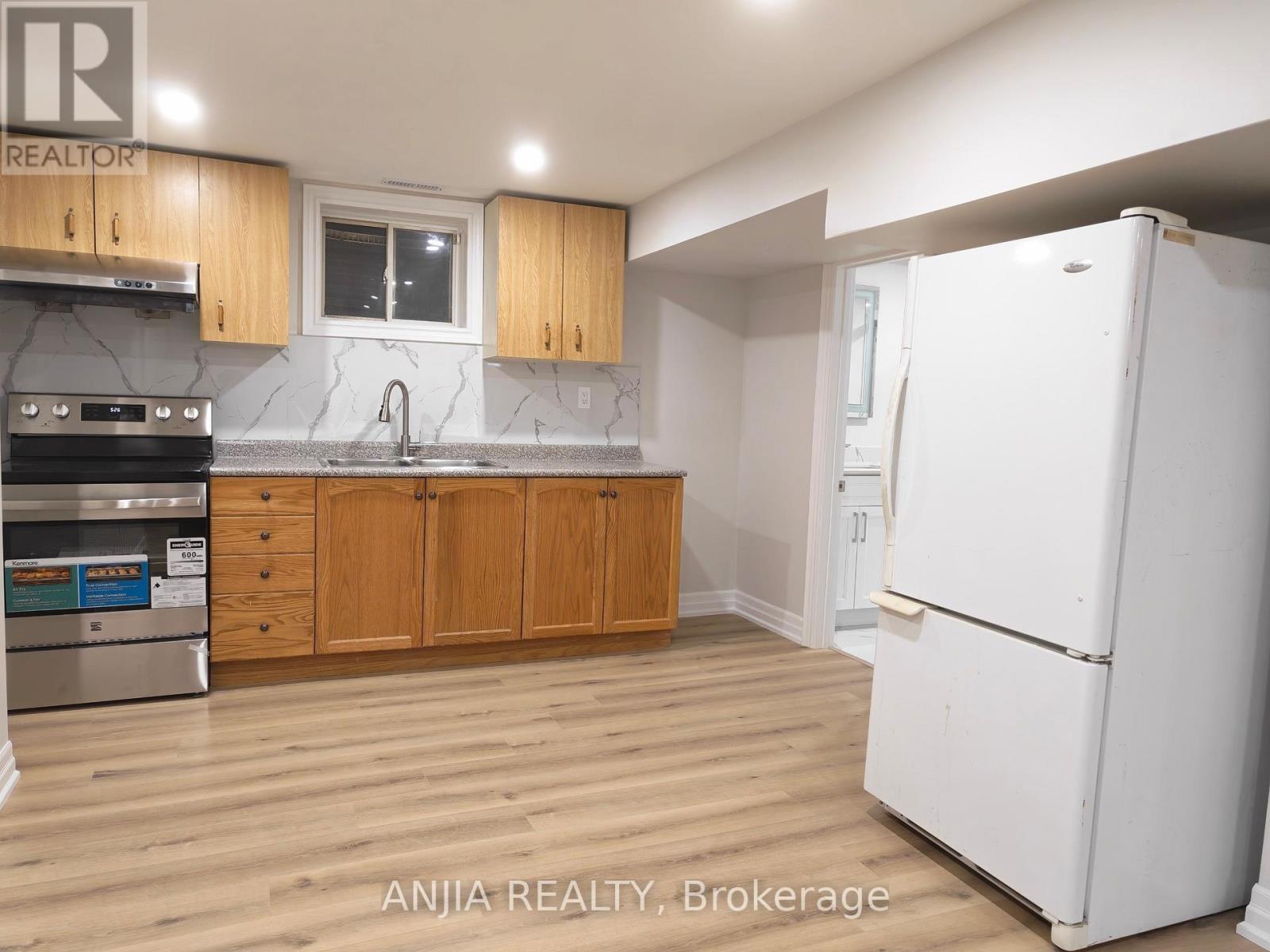 A kitchen with wooden cabinets and a white refrigerator.