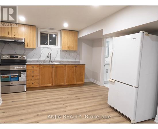 A kitchen with wooden cabinets and a white refrigerator.