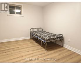 A bedroom with a bed and wooden flooring.