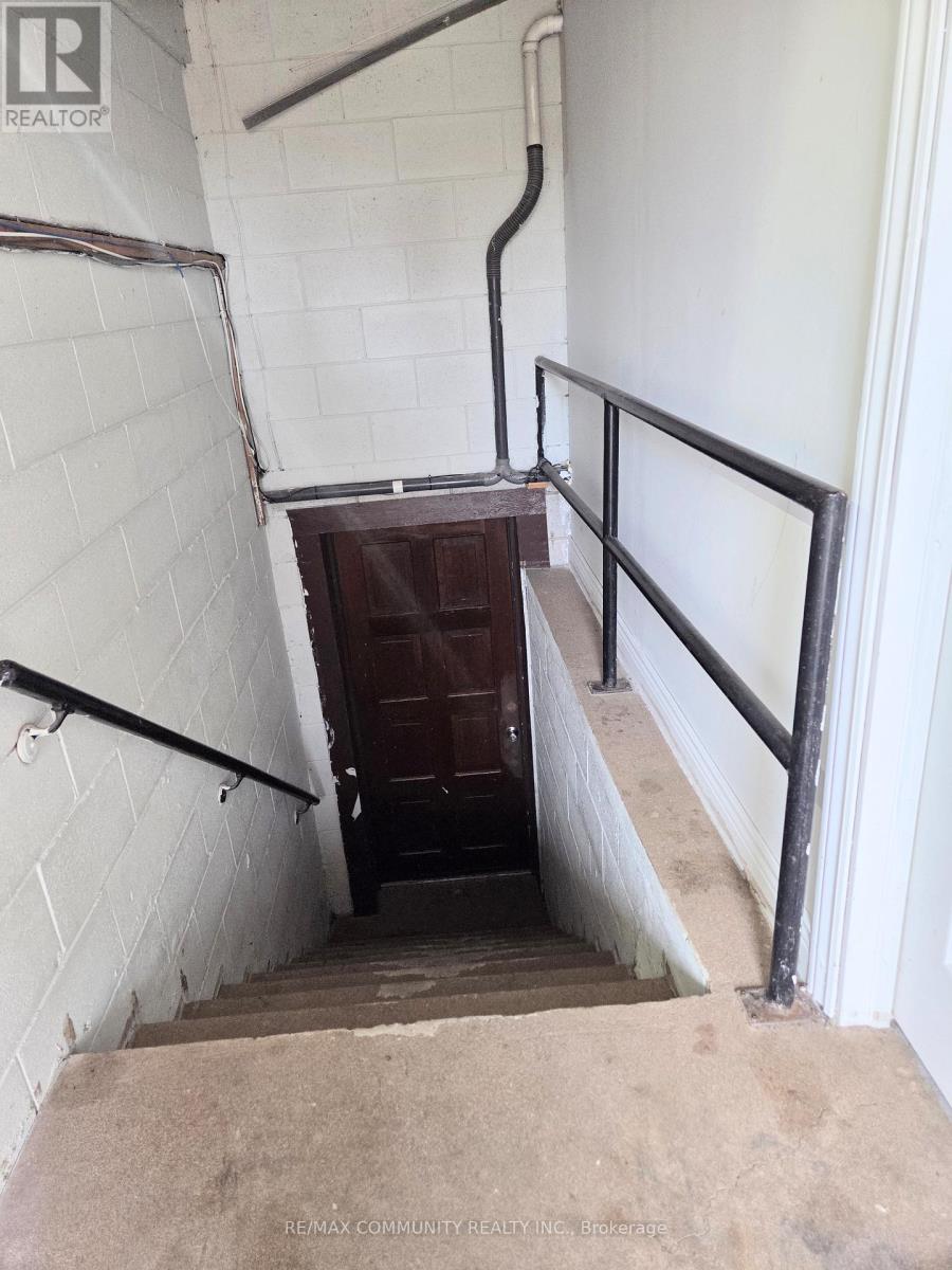 A stairway with a metal railing and a white wall.