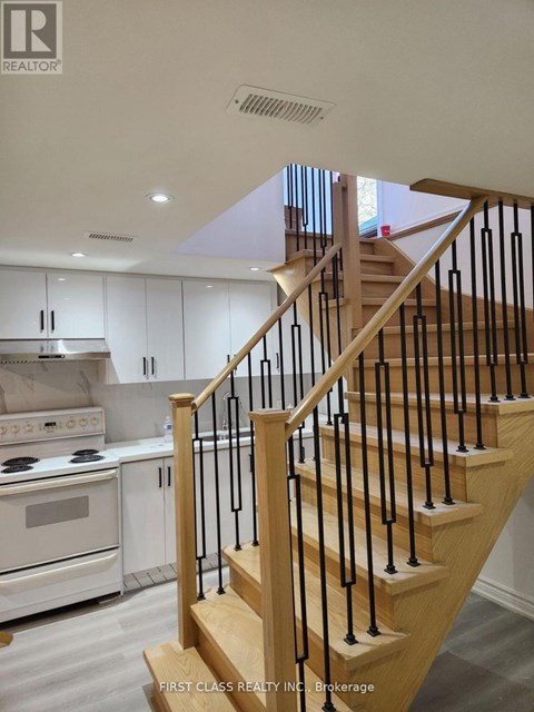 A staircase with a black railing and wooden steps.