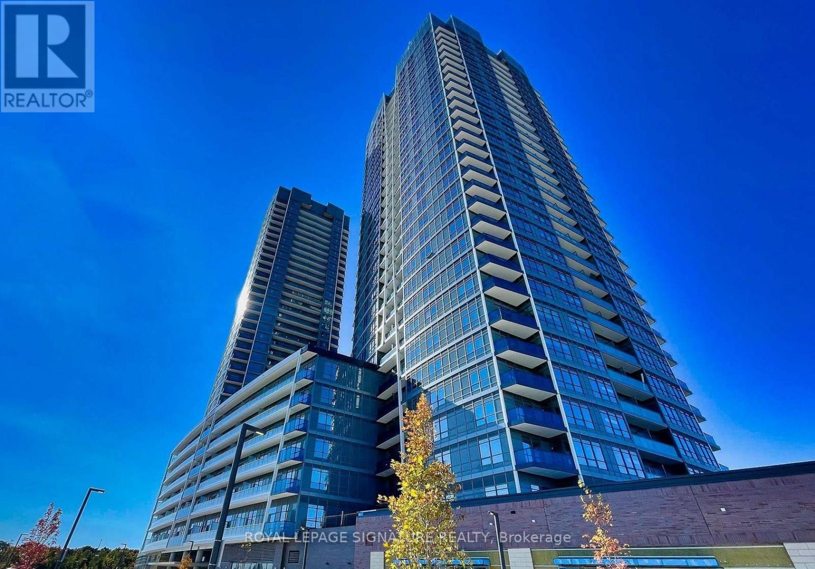 Two modern high-rise buildings are shown with a clear blue sky in the background.