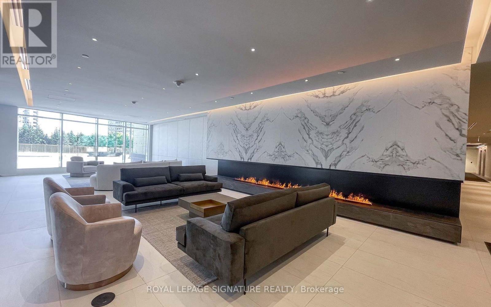 A modern living room with a fireplace and a large marble wall.