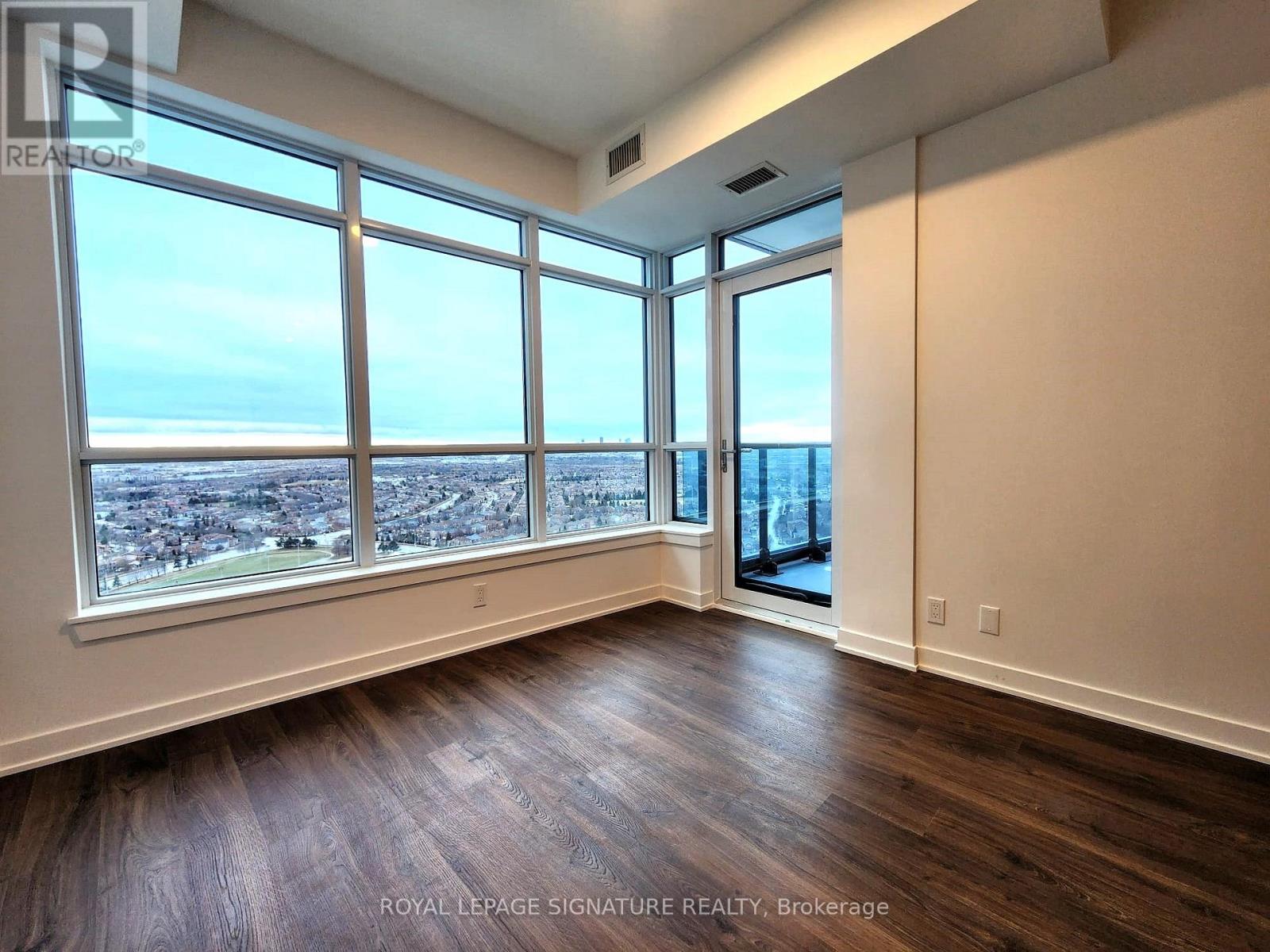 A room with a view of a cityscape through large windows.