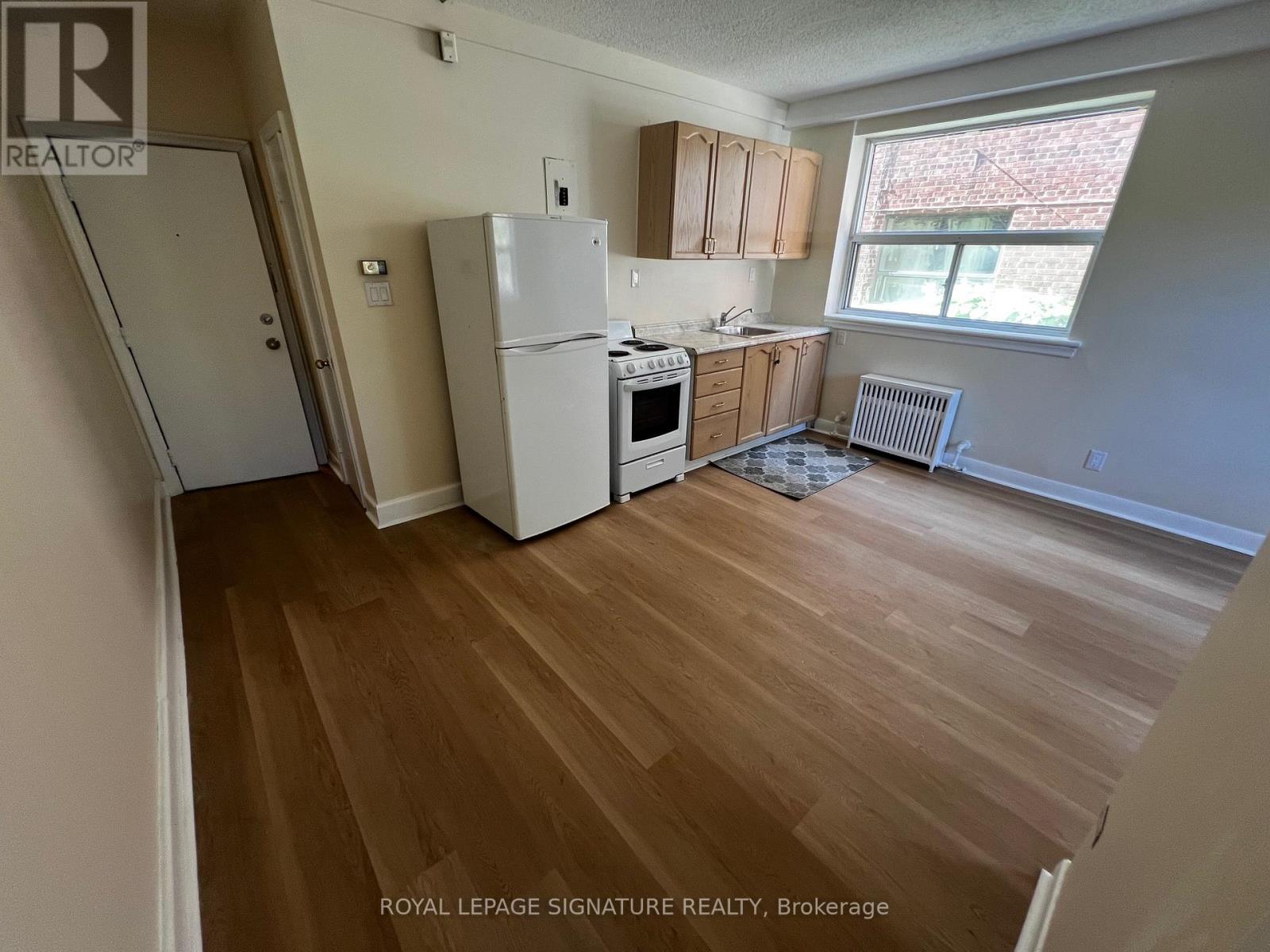 A kitchen with wooden floors and white appliances.
