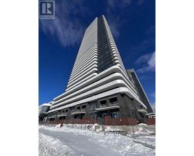 A tall building with a curved top is under construction with snow on the ground.