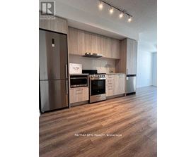 A modern kitchen with wooden cabinets and stainless steel appliances.