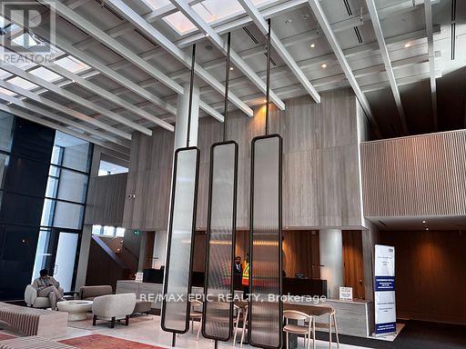 A modern office lobby with a reception desk and chairs.