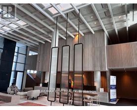 A modern office lobby with a reception desk and chairs.
