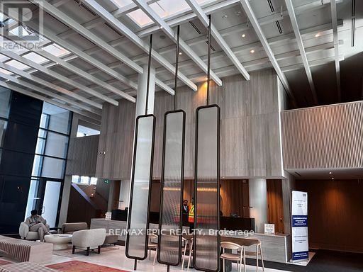 A modern office lobby with a reception desk and chairs.
