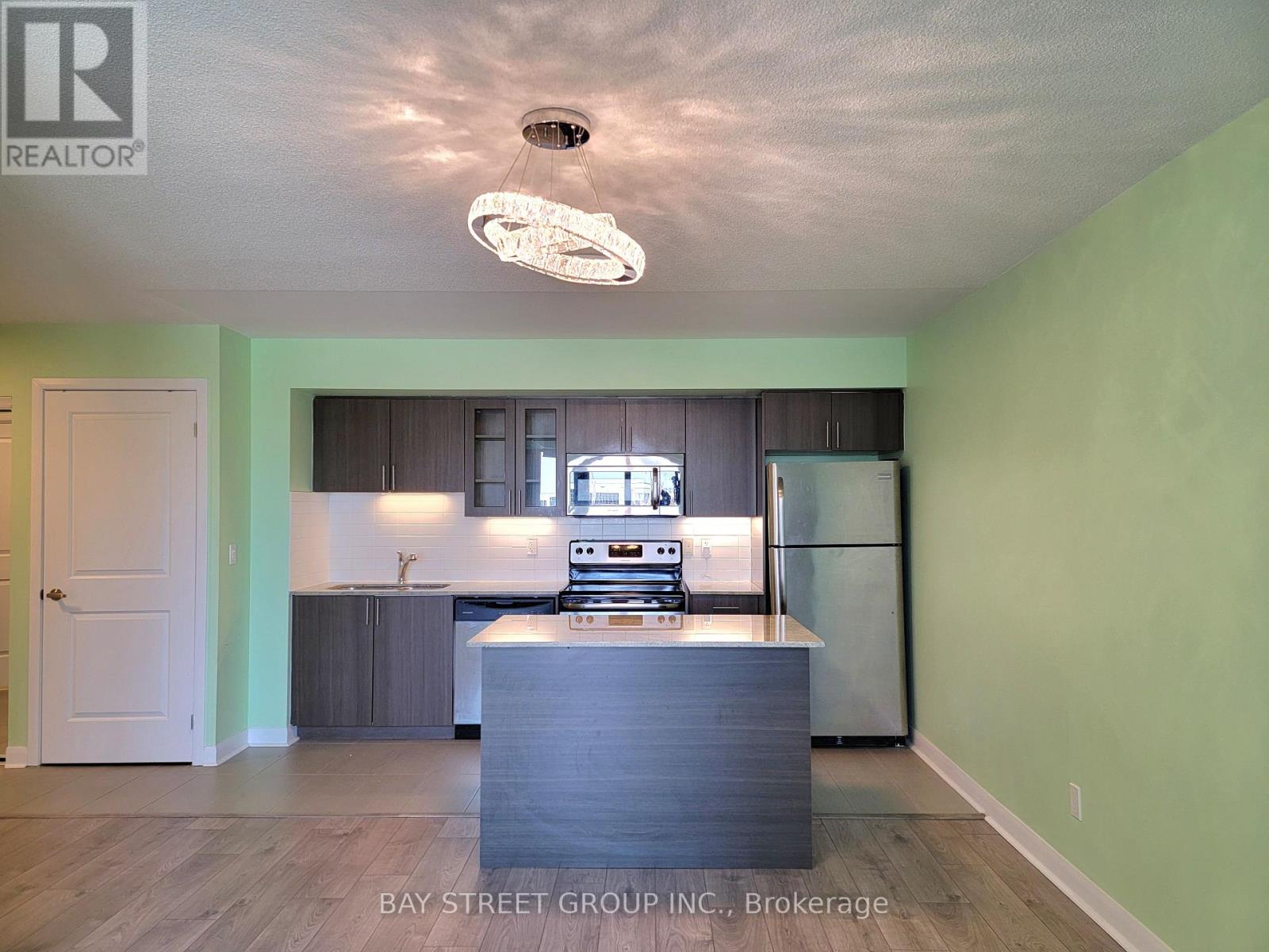 A kitchen with a refrigerator, stove, and oven.