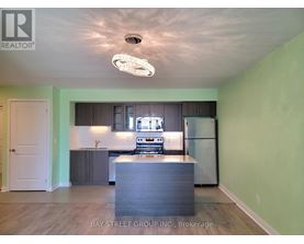 A kitchen with a refrigerator, stove, and oven.