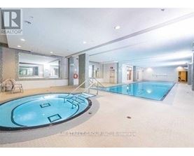 A swimming pool inside a building with a sign that says "REALTOR".