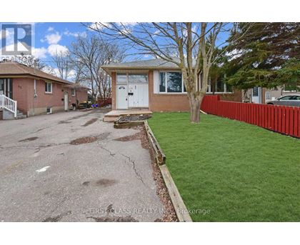 A house with a red fence and a tree in front of it.