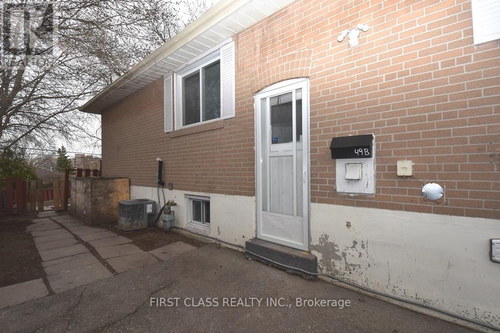 A brick house with a white door and a mailbox on the right side.