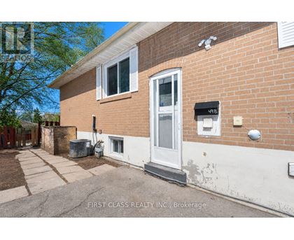 A brick house with a white door and a mailbox on the right side.