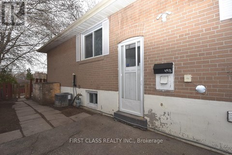 A brick house with a white door and a mailbox on the right side.