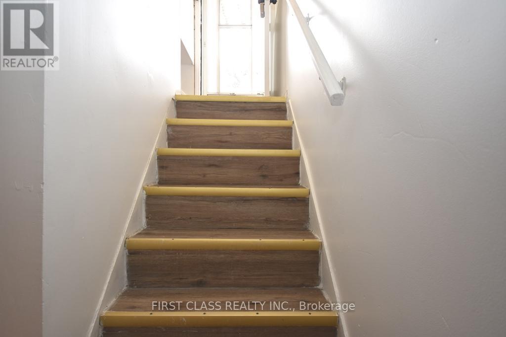 A staircase with wooden steps and yellow handrails.