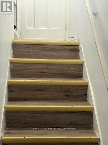 A staircase with wooden steps and yellow handrails.