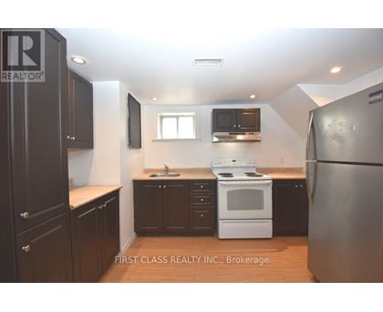 A kitchen with dark brown cabinets and a white stove top oven.