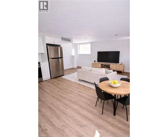 A modern living room with a television, a couch, and a dining table.