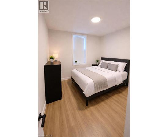 A bedroom with a bed, nightstand, and lamp.