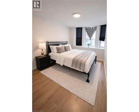 A bedroom with a bed, nightstand, and window.