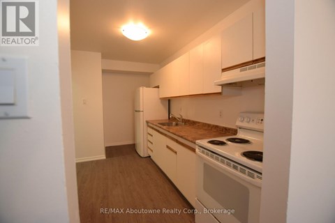 A small kitchen with a stove and cabinets.