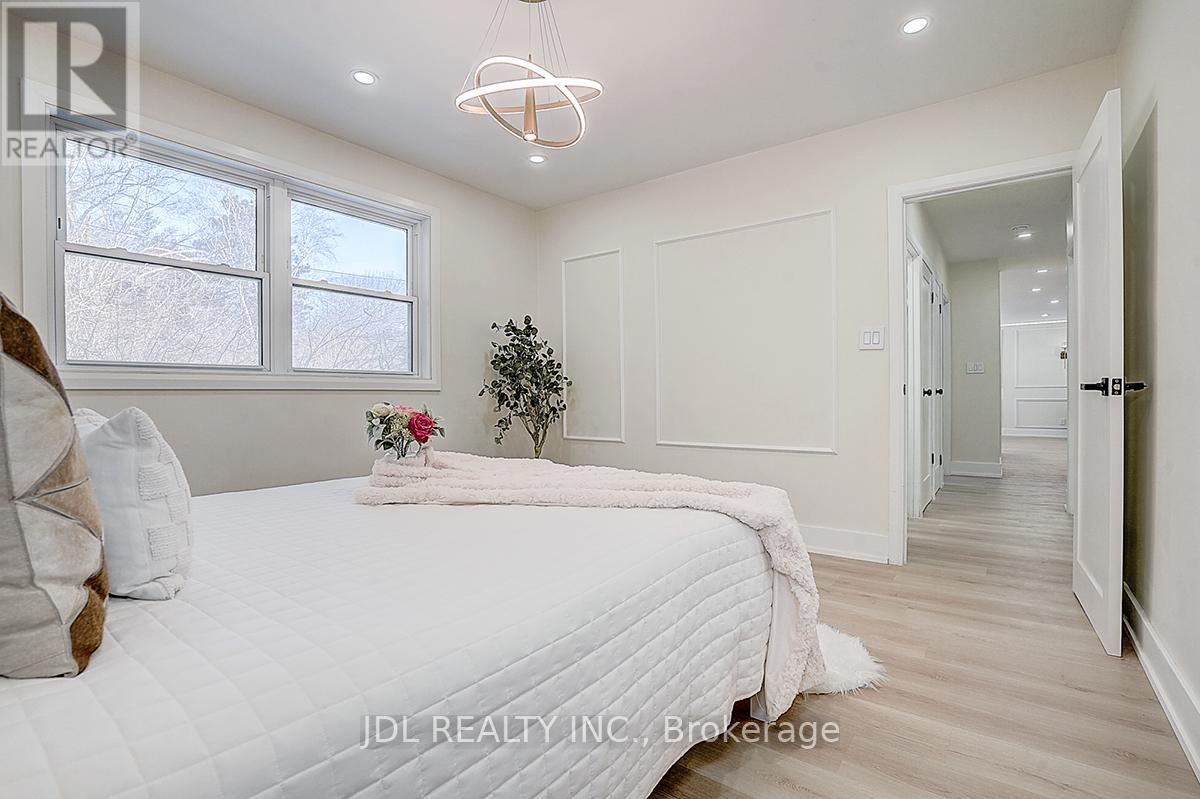 A bedroom with a large bed and a chandelier.