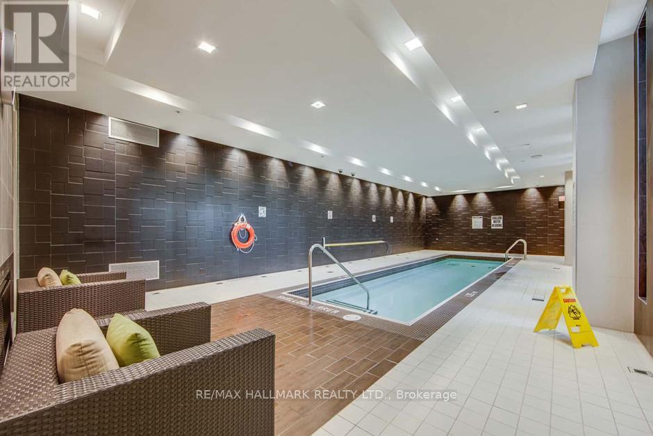 A large indoor swimming pool with a diving board and lounge chairs.