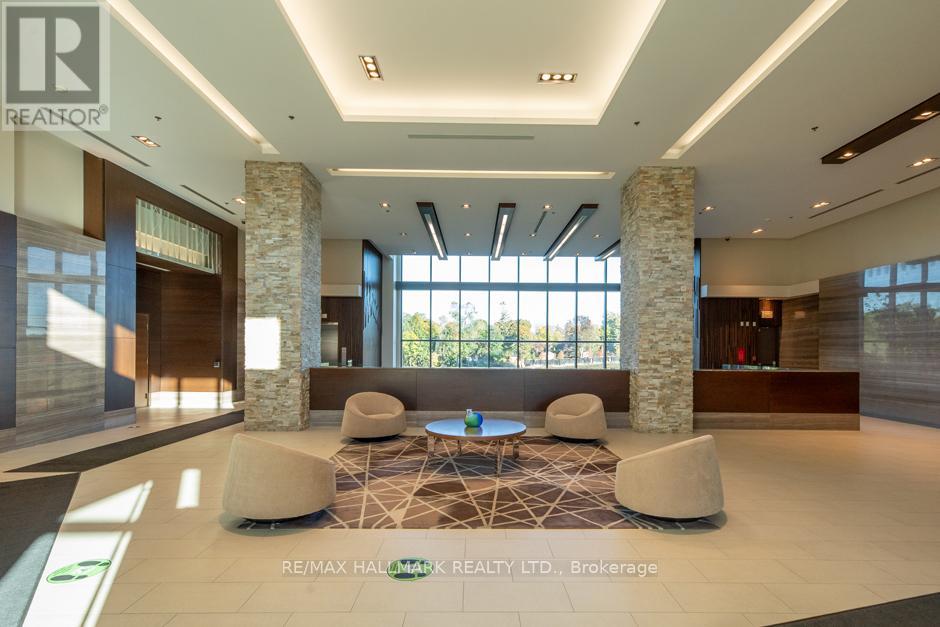 A spacious lobby with a large area rug and a seating arrangement with a coffee table in the center.