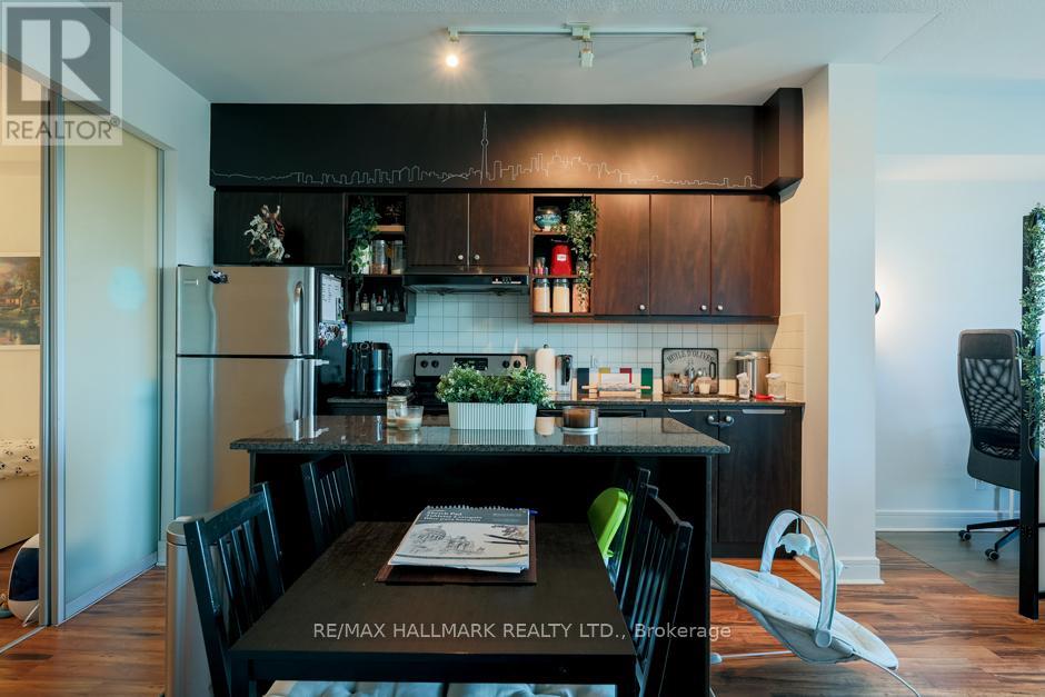 A kitchen with a table and chairs in the foreground and a refrigerator in the background.
