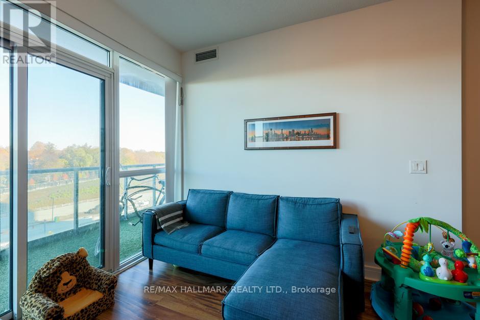 A living room with a blue couch and a teddy bear on the floor.