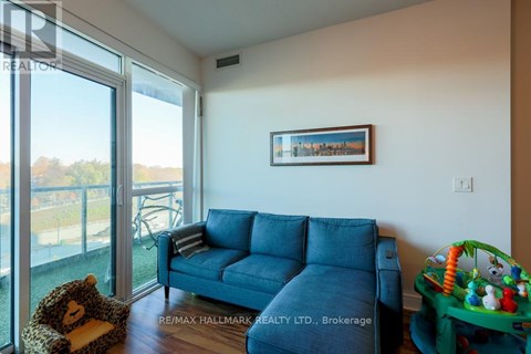 A living room with a blue couch and a teddy bear on the floor.