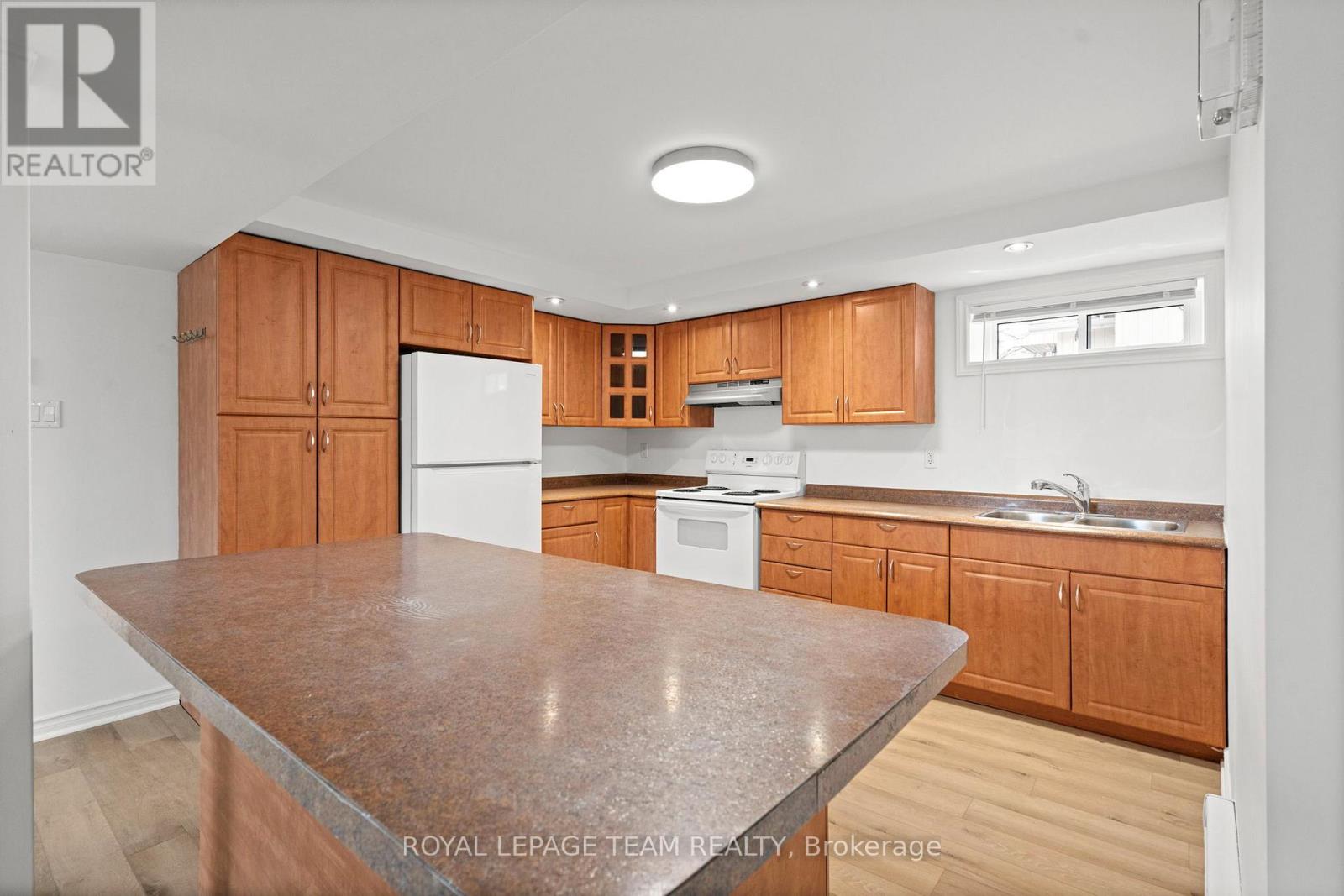 A kitchen with wooden cabinets and a granite countertop.