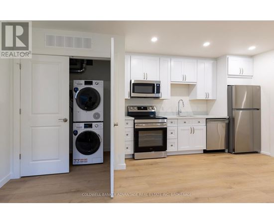 A kitchen with white cabinets and stainless steel appliances.