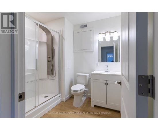 A white bathroom with a toilet, sink, and shower.