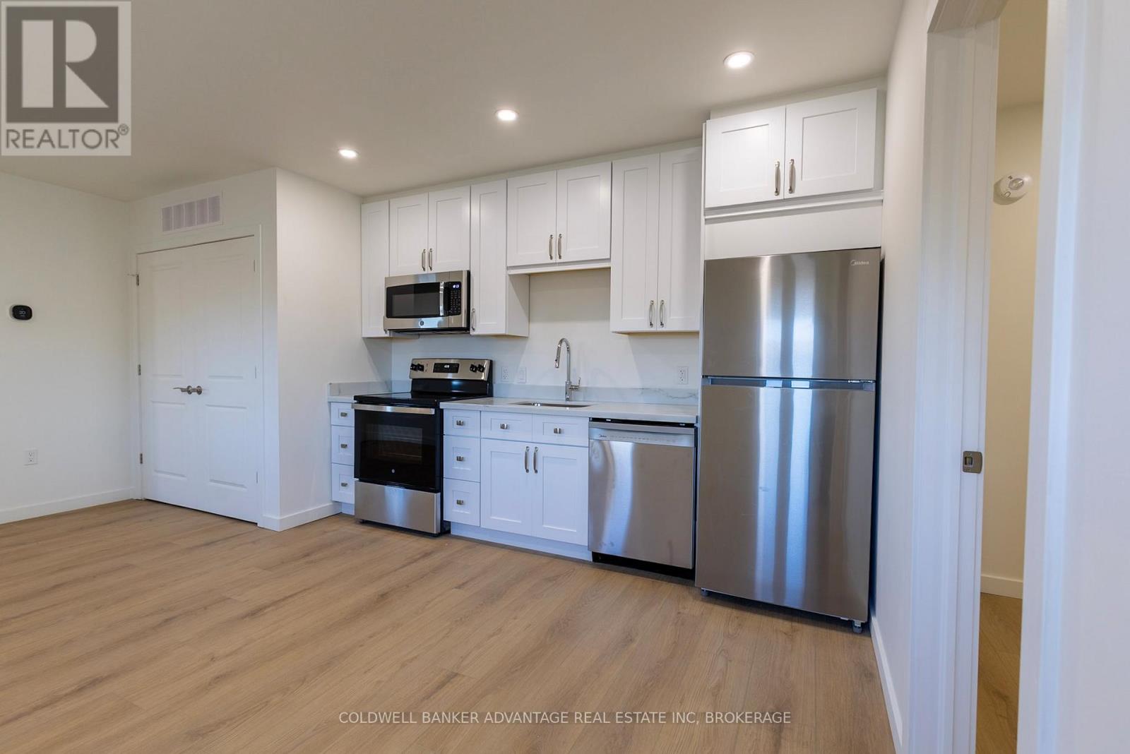 A kitchen with white cabinets and stainless steel appliances.
