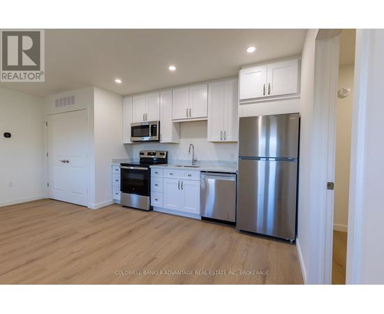 A kitchen with white cabinets and stainless steel appliances.