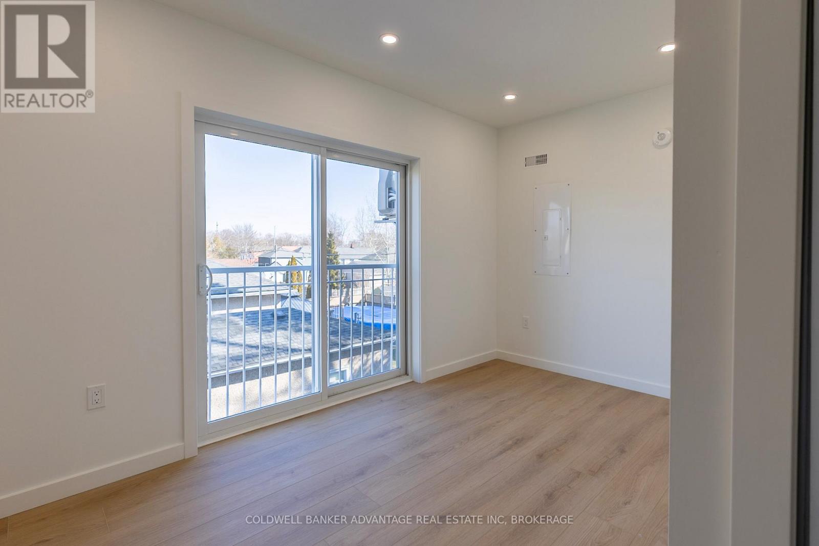 A room with a sliding glass door leading to a balcony.