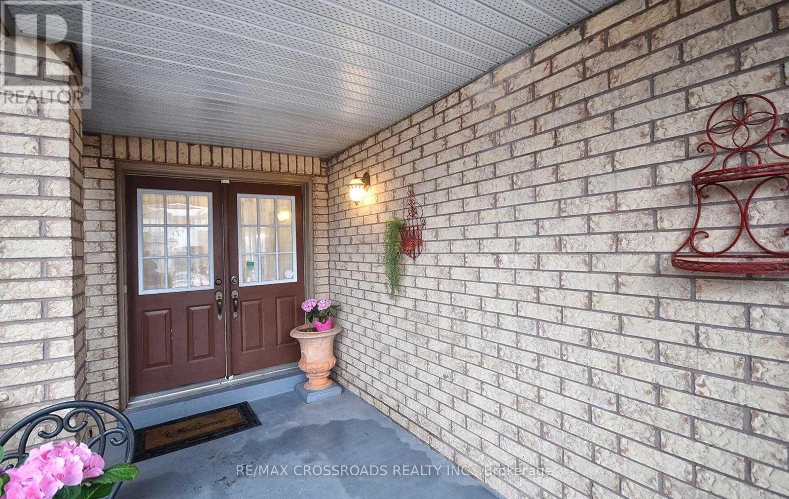 A front porch with a brick wall and a wooden door.