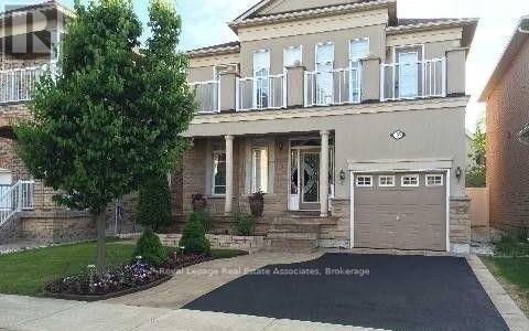 A two-story house with a garage and a driveway in front.