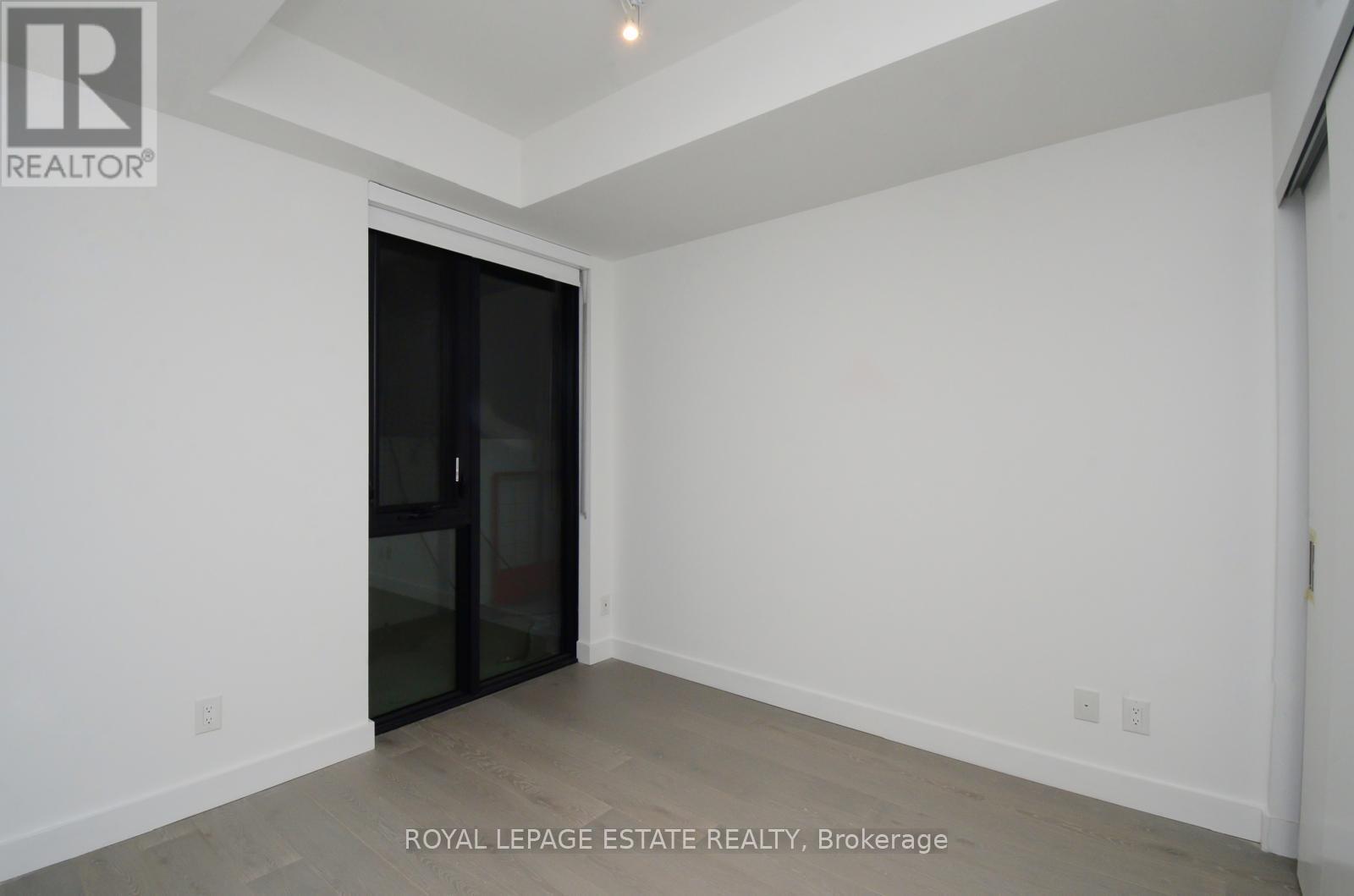 A white room with a sliding door and a wooden floor.