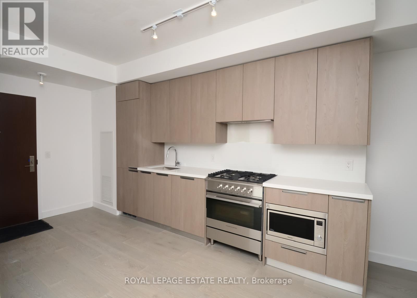 A kitchen with beige cabinets and stainless steel appliances.